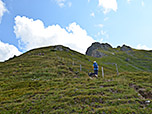 Wir wandern über einen Wiesenhang bergauf