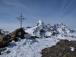 Das kleine Gipfelkreuz des Eiskofel vor der Königsspitze und dem Ortler im Hintergrund