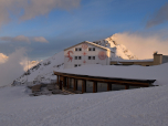 Die ersten Sonnenstrahlen treffen auf das Berghaus Diavolezza