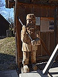 Hölzerner Bergmann neben der Glocke