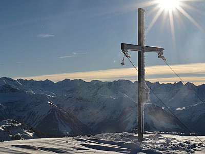 Das Gipfelkreuz am Juifen mit dem Karwendelgebirge im Hintergrund