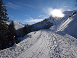 Die Sonne lugt im Süden hinter dem Sonntagsköpfl hervor