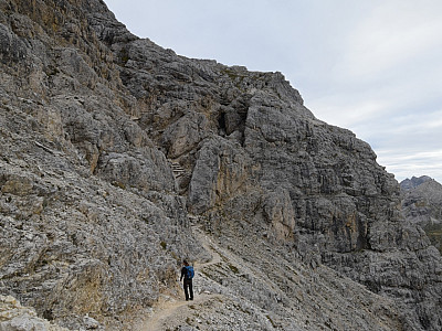 Zwischen den Felsen deuten Baumstämme den Beginn des versicherten Steigs an