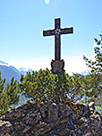 Das Gipfelkreuz der Kneifelspitze steht auf der Hüttenterrasse