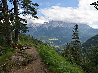 Von einer Bank kann man die Aussicht auf das Wettersteingebirge genießen