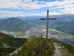 Das Gipfelkreuz des Mittergernkopf  mit Garmisch-Partenkirchen im Hintergrund