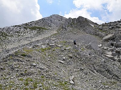 Rechts im Norden des Gipfels führt uns der Weg durch groben Schotter 