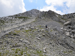 Rechts im Norden des Gipfels führt uns der Weg durch groben Schotter