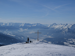 Der Blick am Gipfelkreuz vorbei in das Inntal