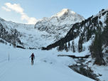 Flach geht es neben der Langlaufloipe tiefer in das Tal
