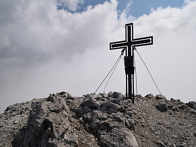 Das Gipfelkreuz des Lärchegg vor einer Wolkenwand