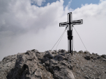 Das Gipfelkreuz des Lärchegg vor einer Wolkenwand