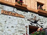 Das Hüttenschild der Alm neben dem Eingang