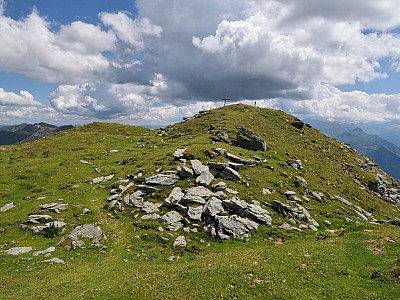 Über mit Steinen durchsetzte Wiesen steigen wir nach Südosten zum Gipfelkreuz auf