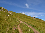 Wir wandern über eine grasige Flanke bergauf