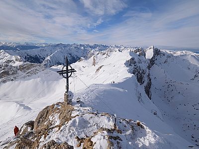 Hinter dem Gipfelkreuz der Grat zum Roßkopf