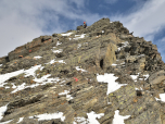 Kletternd steigen wir am Drahtseil die letzten Meter auf