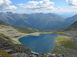 Im Hintergrund zeigen sich die Spitzen der Dolomiten 