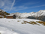 Wir passieren eine kleine Hütte und ein Wetterkreuz