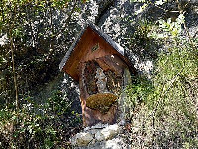 Die kleine Madonna steht auf einem Baumpilz