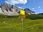 Wegweiser bei der Hütte, im Hintergrund die Kalkkögel