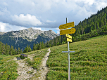 Wegweiser an der Alm mit Blick zur Krapfenkarspitze