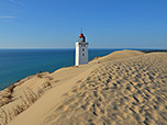 Ein Postkartenmotiv: Leuchtturm im Dünensand