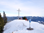 Am Gipfelkreuz machen sich die Skitourengeher fertig für die Abfahrt