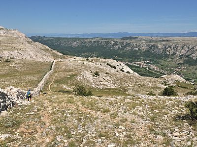 Entlang einer Mauer steigen wir Richtung Süden ab, rechts Draga Bascanska