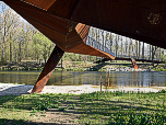Wir marschieren unter einer rostbraunen Fußgängerbrücke weiter flussabwärts