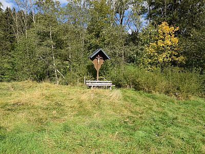 Auf einer Weide lässt es sich an diesem Wegkreuz gut rasten