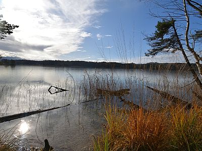 Die Sonne kommt zum Vorschein und spiegelt sich im Großen Ostersee