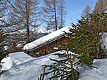 Wir passieren eine verschneite Holzhütte