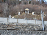 Abgetrennt durch Straße und Bahngeleise befindet sich ein Kreuzweg am Hang