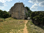 Hinter der Kapelle führt der Weg rechts an dem Felsen vorbei